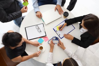 Toplantı salonundaki masada çalışan bir grup iş adamı.