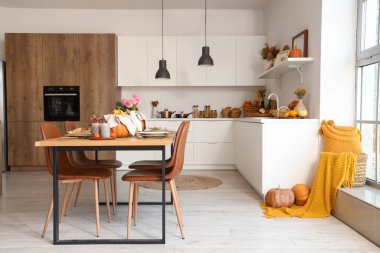 Yemek masası ve balkabağı servis edilen modern mutfağın içi.