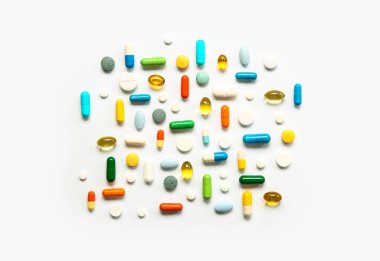 Balık yağı kapsülleri ve beyaz arka planda farklı haplar.