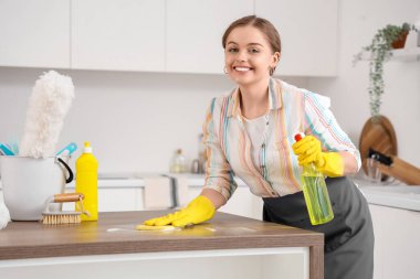 Mutfakta deterjanı olan kadın temizlikçi.