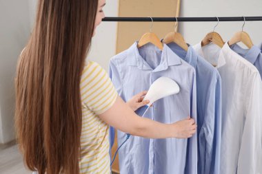 Güzel, genç bir kadın. Buharlı giysileriyle evde.