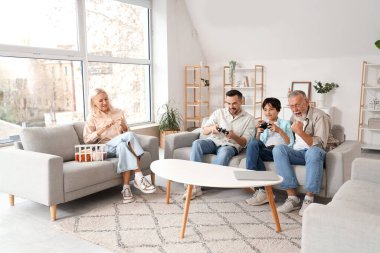 Ailesiyle evde video oyunu oynayan küçük bir çocuk.