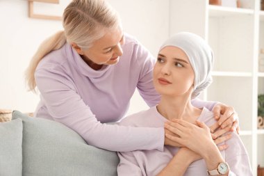 Kemoterapiden sonra genç bir kadın. Annesi evde sarılırken. Mide kanseri kavramı