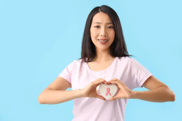 Jovem Mulher Asiática Com Biscoito Fazendo Gesto Coração Fundo Azul — Fotografia de Stock