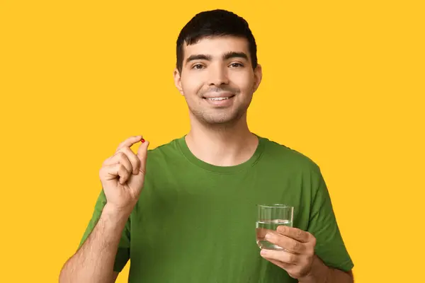 Young Man Vitamin Pill Glass Water Yellow Background — Stock Photo, Image