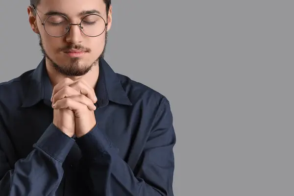 Νεαρός Άνδρας Που Προσεύχεται Γκρίζο Φόντο — Φωτογραφία Αρχείου