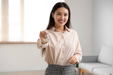 Dairesinde anahtarı olan Asyalı emlakçı.