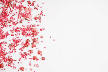 Beyaz arka planda serpiştirilmiş tatlı pembe serpintiler