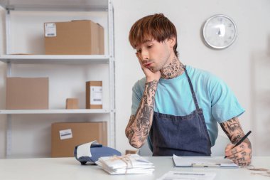 Depodaki ödeme terminalinde çalışan genç bir satıcı.