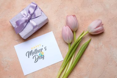 Laleli ve bej renkli grunge arkaplanlı hediye kutulu bir kartpostal. Anneler Günü kutlaması