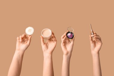 Göz falı, toz ve göz kalemi bej arka planda olan kadın elleri