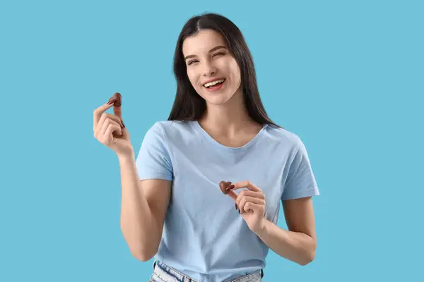 Junge Frau Mit Herzförmigen Schokoladenbonbons Auf Blauem Hintergrund — Stockfoto