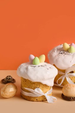 Lezzetli Paskalya pastaları ve renkli arka planda boyanmış yumurtalar. Üst görünüm