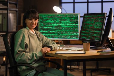 Geceleri bilgisayar monitörleriyle çalışan kadın programcı