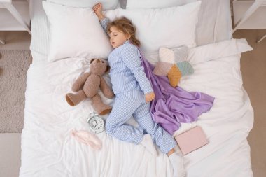 Uyuyan küçük kız yatakta süper güçlerin hayalini kuruyor