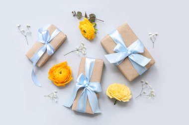 Mavi arka planda çiçekler olan güzel paketlenmiş hediye kutuları.