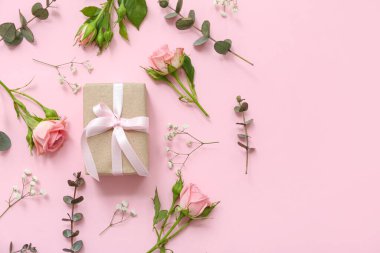 Pembe arka planda bahar çiçekleri olan güzel paketlenmiş hediye kutusu.