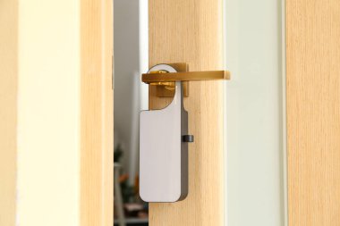 Otel odasında askılı bej bir kapı.