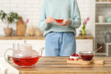 Mutfaktaki masada çaydanlık ve kızılcık reçeli var.