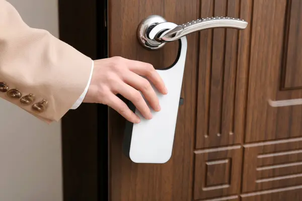 Male hand holding door hanger in hotel room