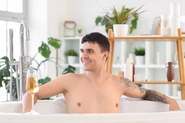 Genç adam odada banyo yapıyor.