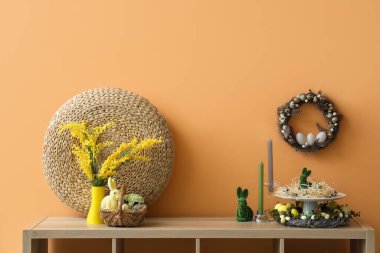 Paskalya dekorlu raflar ve turuncu duvarlı çelenkler.