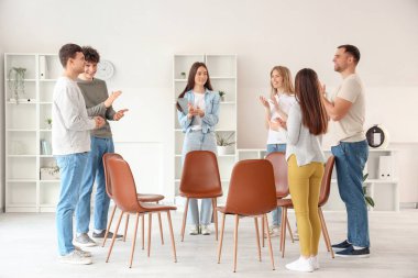 Grup terapisinde ellerini çırpan gençler.