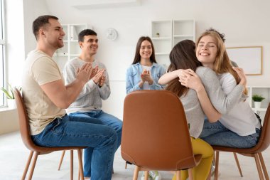 Grup terapisinde sarılan genç kadınlar