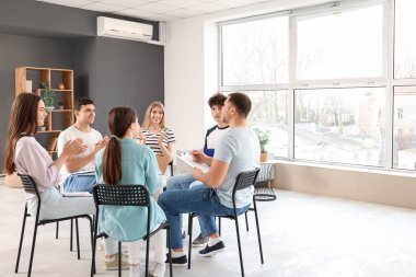 Grup terapisinde ellerini çırpan gençler.