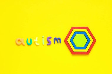 Kelime AUTISM ve oyuncaklar sarı arka planda