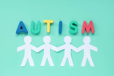 Kelime AUTISM, kağıt insanlar ve pembe arka planda farkındalık kurdelesi. Otistik bozukluk kavramı