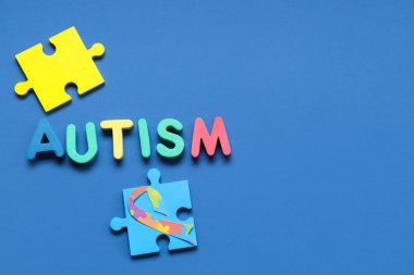 Mavi arka planda kelime AUTISM ve bulmaca. Otistik bozukluk kavramı