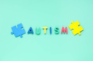 Kelime AUTISM ve Cyan arka plan bulmacası. Otistik bozukluk kavramı