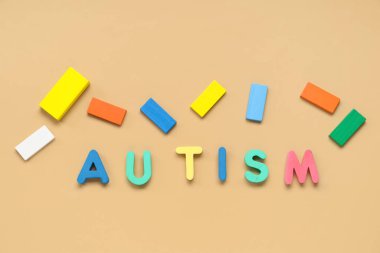 Bej arkaplanda renkli blokları olan sözcük AUTISM