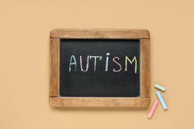 Bej arka planda kelime AUTISM karatahta. Otizm Bozukluğu