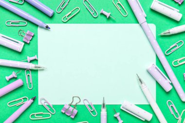 Yeşil zemin üzerinde farklı kırtasiye kağıtları olan bir sayfa. Okul bitti. Üst görünüm