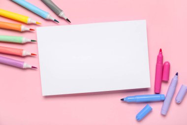 Pembe arka planda keçeli kalemleri olan bir kağıt. Okul bitti. Üst görünüm