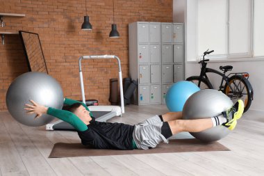 Sportif genç adam spor salonunda paspaslı spor yapıyor.