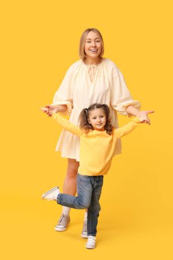 Anne sarı arka planda çocuğuyla oynuyor. Anneler Günü