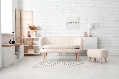 Rahat kanepe ve puf ile aydınlık oturma odasının içi