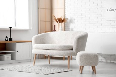 Rahat kanepe ve puf ile aydınlık oturma odasının içi