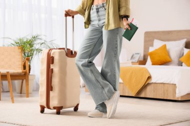 Otel odasında pasaportu ve bavulu olan bir kadın turist.