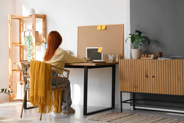 stock image Young woman working with laptop at workplace in office