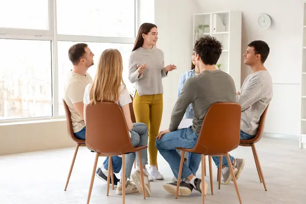 Young woman talking at group therapy session