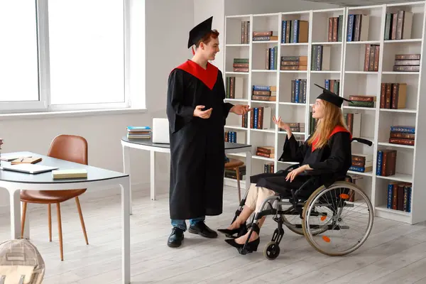 stock image Female graduate in wheelchair chatting with classmate at university