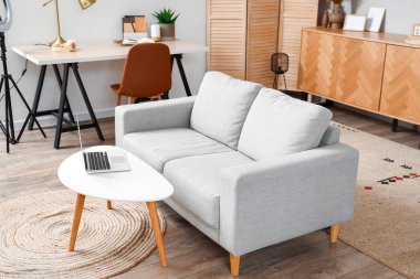 Oturma odasının içinde kanepe ve işyeri var.