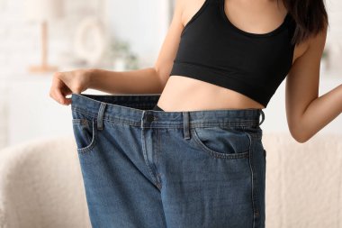 Evde bol kotlu güzel bir Asyalı kadın var. Yakın plan. Kilo verme konsepti