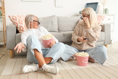 Üç boyutlu gözlüklü olgun bayan arkadaşları evde patlamış mısır izleyip kafalarını karıştırıyorlar.