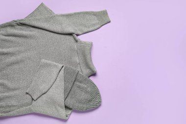 Leylak arkaplanda şık bir kadın süveteri ve şapka