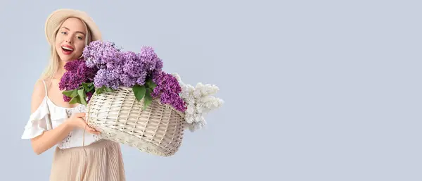 Glad Ung Kvinna Som Innehar Korg Med Lila Blommor Ljus — Stockfoto